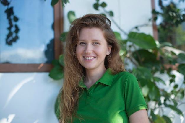 Portrait d'une jeune fille positive près de sa maison concept écologique vie de campagne jardin vert printemps été