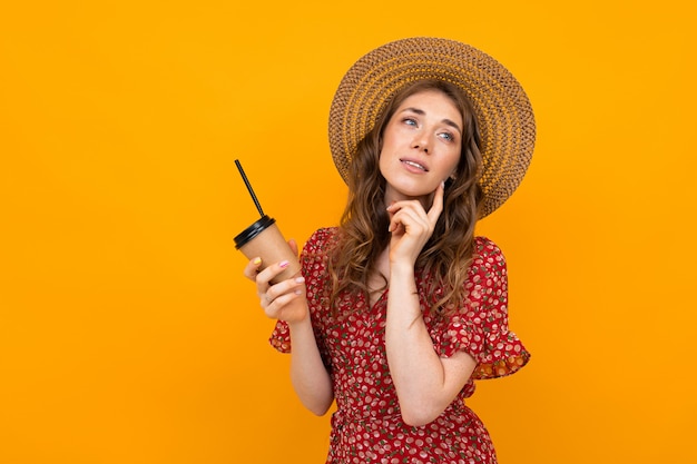 Portrait d'une jeune fille réfléchie dans un chapeau sur fond jaune