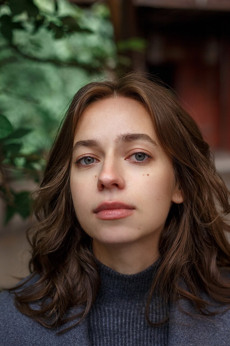 Portrait de jeune fille réfléchie en manteau gris et col roulé posant à l'extérieur