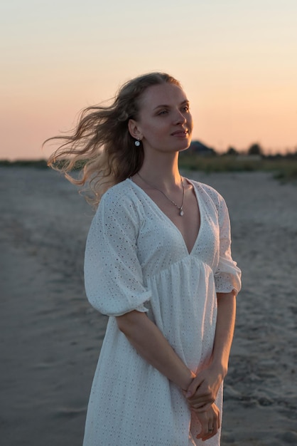 portrait d'une jeune fille en robe blanche au bord de la mer