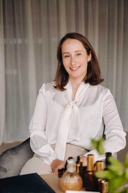 Portrait d'une jeune fille souriante assise dans un fauteuil Un aromathérapeute en blouse blanche est assis au bureau