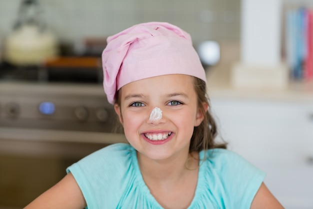 Portrait de jeune fille souriante avec de la farine sur le nez