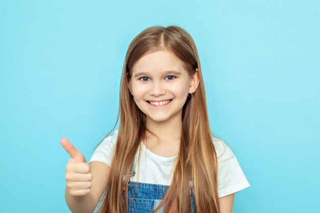 Portrait d'une jeune fille souriante avec un pouce levé.