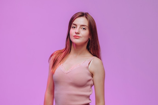 Portrait d'une jeune fille en t-shirt rose sur fond violet