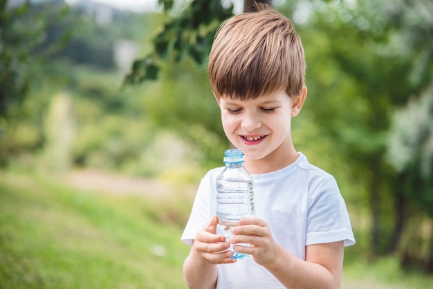 portrait jeune garçon avec une bouteille d'eau