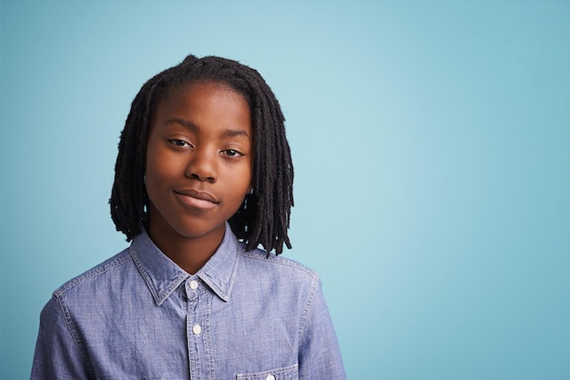 Portrait d'un jeune garçon debout sur un fond bleu