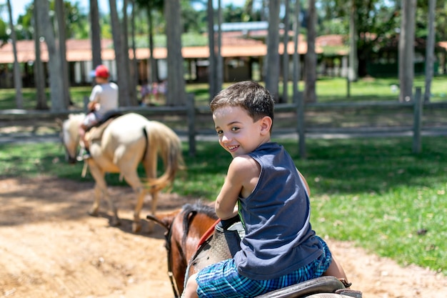 Portrait d'un jeune garçon heureux à cheval