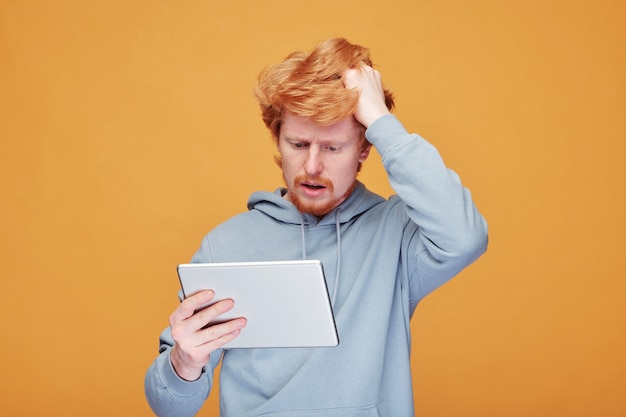 Portrait de jeune gestionnaire SMM rousse positif avec barbe tenant un signe de hashtag