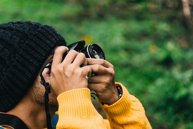 Photo portrait d'un jeune homme adulte tenant un appareil photo et prenant une photo concept de photographie et de film