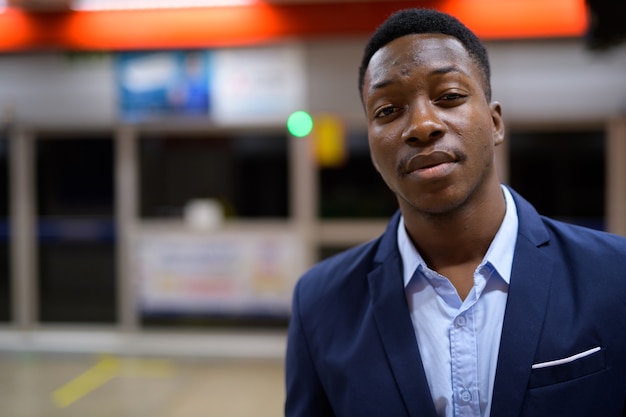 Portrait de jeune homme d'affaires africain beau dans la station de métro