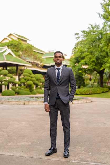 Portrait de jeune homme d'affaires africain beau debout à l'extérieur