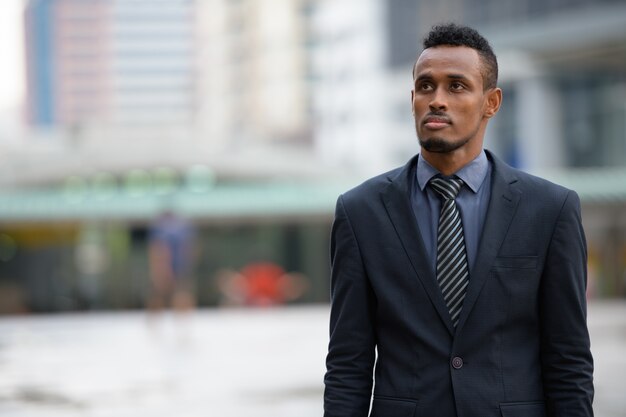 Portrait de jeune homme d'affaires africain dans les rues de la ville à l'extérieur