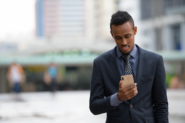 Portrait de jeune homme d'affaires africain dans les rues de la ville à l'extérieur