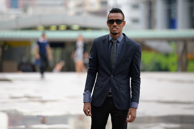 Portrait de jeune homme d'affaires africain dans les rues de la ville à l'extérieur