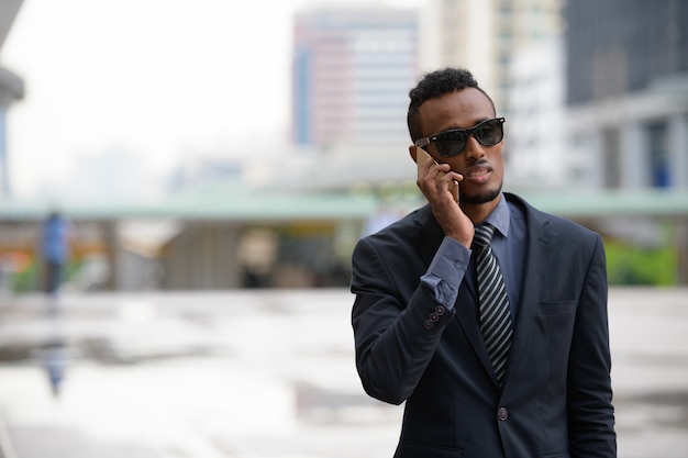 Portrait de jeune homme d'affaires africain dans les rues de la ville à l'extérieur