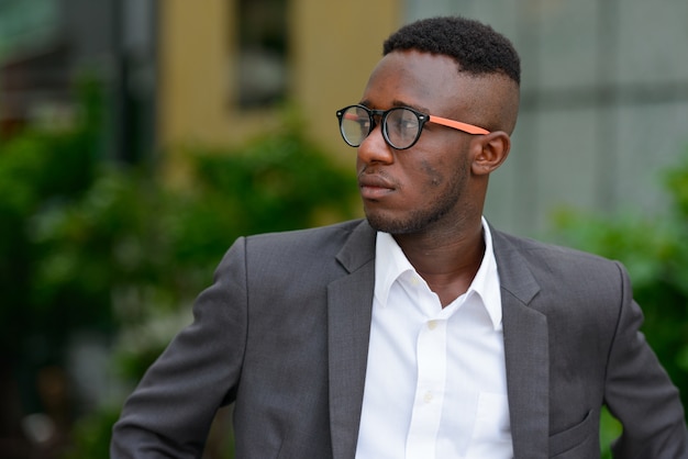 Portrait de jeune homme d'affaires africain dans la ville en plein air