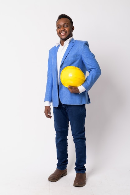 Portrait de jeune homme d'affaires africain portant un costume bleu contre un mur blanc