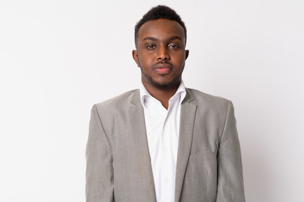 Portrait de jeune homme d'affaires africain portant un costume contre un mur blanc