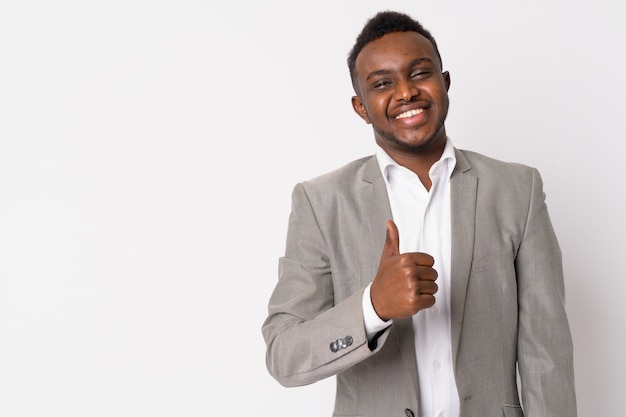 Portrait de jeune homme d'affaires africain portant un costume contre un mur blanc