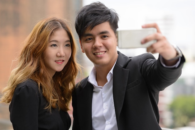 Portrait de jeune homme d'affaires asiatique et jeune femme d'affaires asiatique ensemble dans la ville en plein air