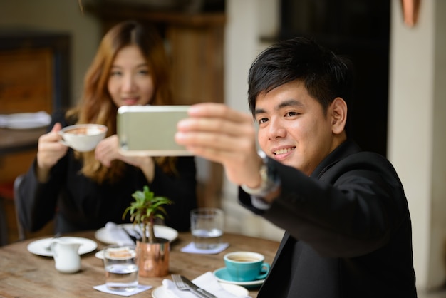 Portrait de jeune homme d'affaires asiatique et jeune femme d'affaires asiatique ensemble se détendre au café