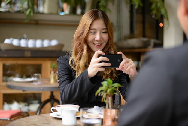 Portrait de jeune homme d'affaires asiatique et jeune femme d'affaires asiatique ensemble se détendre au café