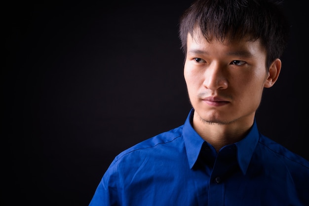 Portrait de jeune homme d'affaires asiatique pensant et regardant ailleurs