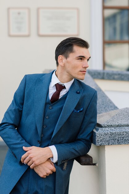 Portrait d'un jeune homme d'affaires attrayant dans l'espace urbain portant un costume et une cravate.