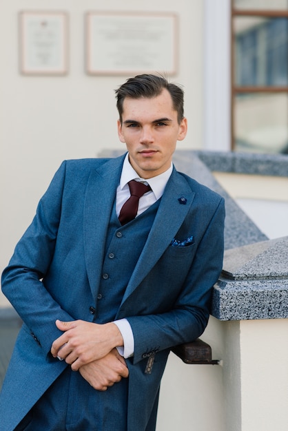 Portrait d'un jeune homme d'affaires attrayant dans la rue urbaine portant un costume et une cravate.