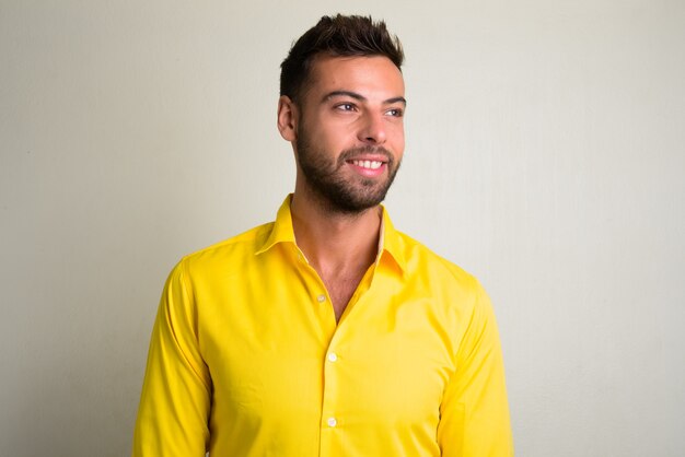 Portrait de jeune homme d'affaires barbu beau portant une chemise jaune sur blanc