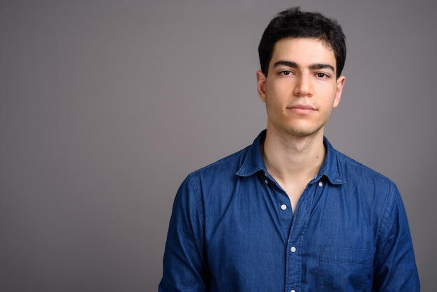 Photo portrait de jeune homme d'affaires beau contre gris