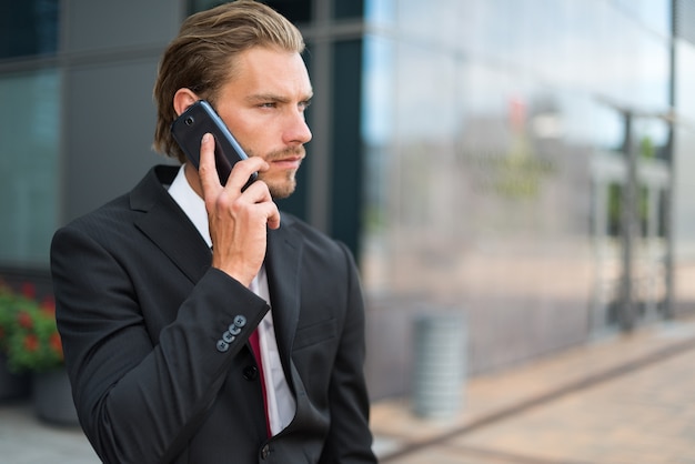 Portrait d&#39;un jeune homme d&#39;affaires beau parler sur son téléphone portable