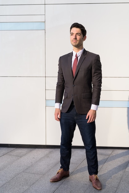 Portrait de jeune homme d'affaires beau portant costume en ville