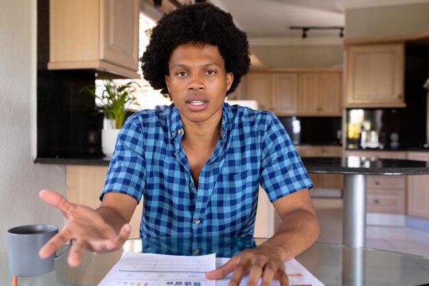 Portrait d'un jeune homme d'affaires biracial confiant lors d'un appel vidéo au bureau à domicile. concept inchangé, de bureau à domicile, d'entreprise et d'indépendant.