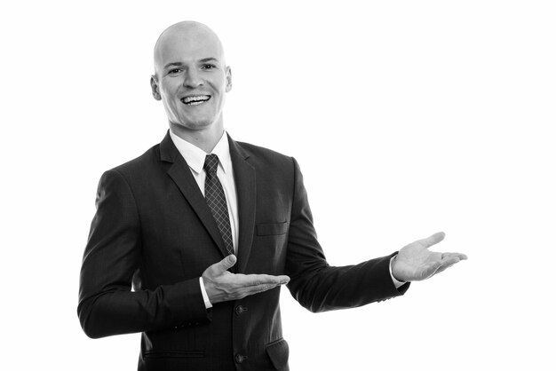 Portrait de jeune homme d'affaires chauve beau en costume isolé sur blanc en noir et blanc