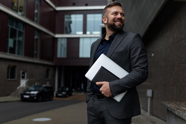 Portrait d'un jeune homme d'affaires européen prospère avec des documents dans ses mains sur le fond de