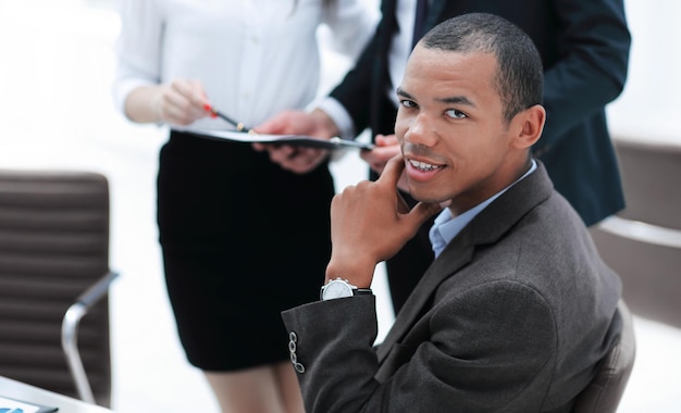 Photo portrait d'un jeune homme d'affaires sur fond de bureau