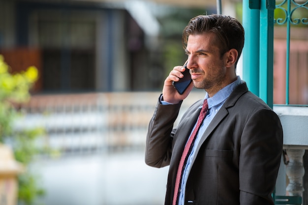 Portrait de jeune homme d'affaires hispanique beau dans la rue à l'extérieur