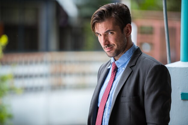 Portrait de jeune homme d'affaires hispanique beau dans la rue à l'extérieur