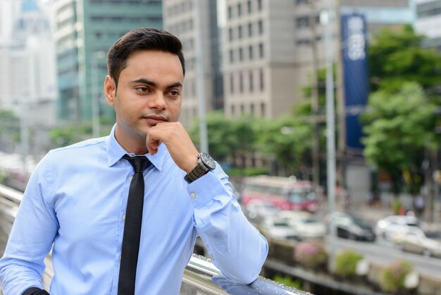 Portrait de jeune homme d'affaires indien beau dans la ville