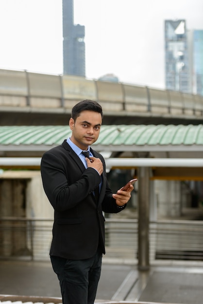 Portrait de jeune homme d'affaires indien beau dans la ville