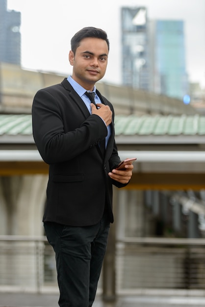 Portrait de jeune homme d'affaires indien beau dans la ville