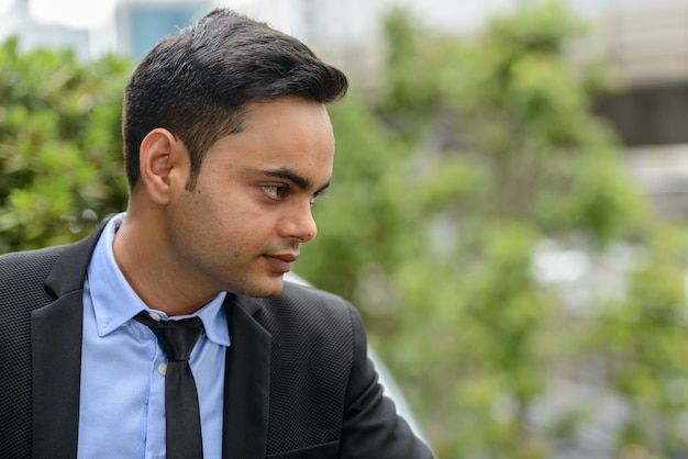 Portrait de jeune homme d'affaires indien beau dans la ville