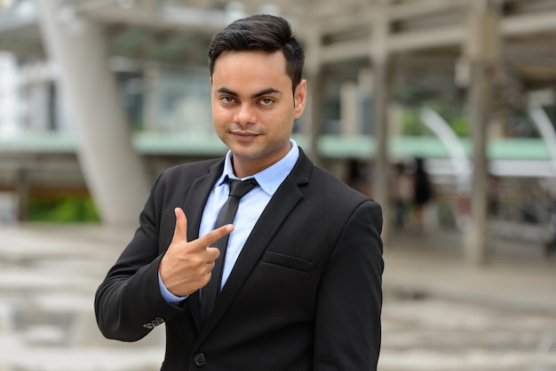 Portrait de jeune homme d'affaires indien beau dans la ville