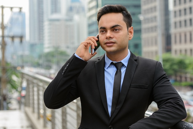 Portrait de jeune homme d'affaires indien beau dans la ville