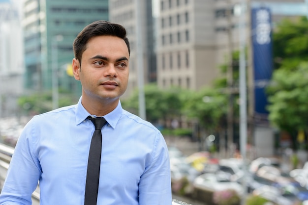 Portrait de jeune homme d'affaires indien beau dans la ville