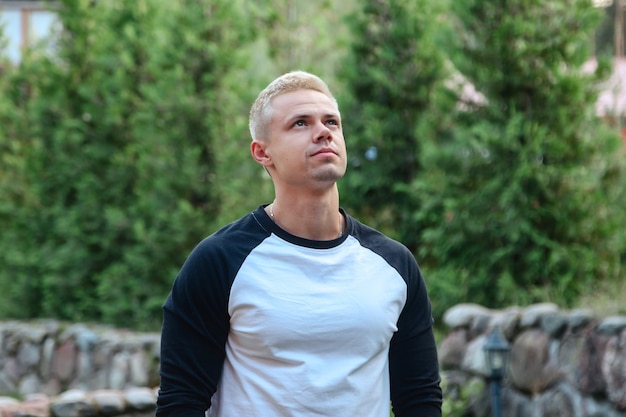 Photo portrait d'un jeune homme d'affaires mignon et branché en milieu rural en plein air. homme séduisant dans des vêtements décontractés à la maison marchant dans un pays rural. inspiration créative et entreprise de démarrage. espace de copie