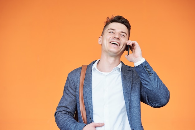 Portrait de jeune homme d'affaires parlant au téléphone et riant des blagues de son partenaire commercial