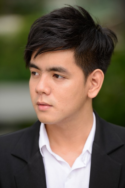 Portrait de jeune homme d'affaires philippin beau dans le parc de la ville en plein air
