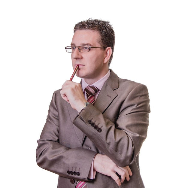 Portrait d'un jeune homme d'affaires réfléchi avec un stylo à la main, isolé sur fond blanc